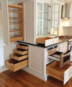 an open kitchen with white cabinets and drawers