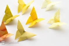 several yellow and white paper butterflies on a white surface