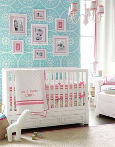 a baby's room decorated in pink, blue and white with pictures on the wall