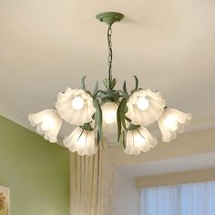 a chandelier hanging from the ceiling in a room with green walls and curtains