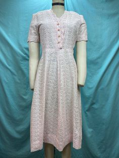 1940s W:27 vintage 40s pink embroidery eyelet cottton shirt dress pearl shank buttons short sleeve  Beautiful 40s vintage dress. Made out of light weight cotton with eyelets and roses embroidery in light powder pink color. Classic shirt dress with scalloped edge V neckline and short sleeves. Hiked natural waist and A-line skirt. Dress with side zipper and non functional pearl shank buttons. Unlined. Photographed on fit form size 2. MEASUREMENTS  Bust: 36" Waist: 27" Hips: 44" Shoulder to waist: 1940s Pink Dress, Feminine Eyelet Dress With Short Sleeves, Short Sleeve Eyelet Dress For Daywear, Feminine Fitted Vintage Dress With Short Sleeves, 1950s Style Short Sleeve Day Dresses, 1950s Style Short Sleeve Summer Dress, 1950s Style Vintage Dress With Short Sleeves For Daywear, 1950s Style Short Sleeve Dresses For Daywear, Pink Vintage Dress For Daywear