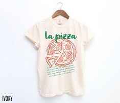 Celebrate your love for Italy's favorite dish with our "La Pizza" t-shirt. Perfect for pizza enthusiasts, this shirt brings a slice of Italian tradition and flavor to your everyday style! The text at the bottom reads, "In Italy, "la pizza" is a symbol of tradition and culinary pride. With fresh ingredients and simple recipes, classics like Margherita reflect the heart of Italian cuisine. Whether in Naples or a small town, pizza in Italy is always an art, not just a meal. We use professional qual Pizza In Italy, Retro Pizza, Pizza Tee, Graphic Tee Men, Aesthetic Italy, Italy Shirt, Italian Aesthetic, Pizza Tshirt, Pizza Shirt