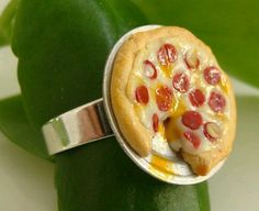 a pizza ring with pepperoni and cheese on it sitting on top of a green leaf