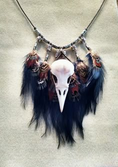 an animal skull is adorned with feathers and beads