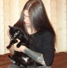 a woman holding a black cat on her lap