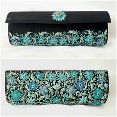 "The perfect wedding purse! A sophisticated and feminine black silk clutch bag, expertly hand embroidered by zardozi artisans. A profusion of petit blue silk flowers are inlaid with emerald gemstones. Each delicate petal and leaf is meticulously outlined with a glittery silver metallic thread, to give a sparkly, opulent 3D effect. Crowned by a beautifully embroidered blue medallion with an emerald cabochon. The word Zardozi means \"gold thread\". It is an elaborate and intricate embroidery art f Black Hand Embellished Clutch For Wedding, Festive Floral Embroidered Evening Bag For Formal Occasions, Festive Formal Evening Bag With Floral Embroidery, Traditional Black Evening Bag For Wedding, Festive Floral Embroidery Evening Bag, Traditional Floral Embroidered Evening Bag, Evening Clutch With Floral Embroidery For Festive Occasions, Elegant Festive Clutch With Floral Embroidery, Festive Evening Clutch With Floral Embroidery