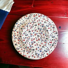 a plate with red, white and blue stars on it sitting on a wooden table