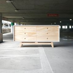 a wooden dresser sitting in an empty parking garage