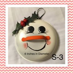 a snowman ornament with holly on it's head and the words 6 inches in diamet