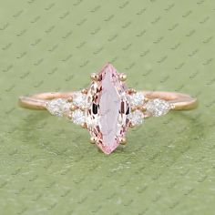 an oval cut pink sapphire and diamond ring with three side stones in yellow gold setting