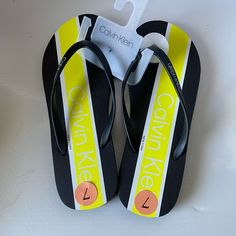 Add Some Shine To Your Beach Wear With The Slip-On Calvin Klein Sarinah Sandal! Man-Made Upper In A Flip-Flop Silhouette. Soft Man-Made Lining. Lightly Padded Footbed. Man-Made Outsole. Imported. Yellow Synthetic Flat Flip Flops, Yellow Flat Synthetic Flip Flops, Yellow Non-slip Synthetic Flip Flops, Yellow Sporty Non-slip Sandals, Calvin Klein Black Sandals For Summer, Yellow Synthetic Flip Flops For Beach Season, Calvin Klein Sandals For Summer Beach, Calvin Klein Beach Sandals For Summer, Calvin Klein Summer Beach Sandals