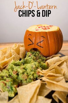 an orange pumpkin sitting next to chips and guacamole on top of a table