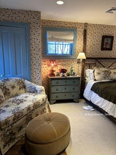 a bed room with a neatly made bed next to a chair and ottoman on the floor