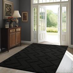 a large black rug is in front of an open door