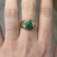 This Mid-Century cocktail ring features a cabochon cut natural green jade in 14k rose gold. The stone has a marvelous, tropical green hue set in glowing 14k rose gold. Reaching 5.48mm above the finger and weighing 4.9 grams, this Mid-Century statement cocktail ring is an outstanding piece of vintage jewelry! Composition: 14 Karat Rose Gold Ring Size: 10.5 Primary Stone: Green Jade Shape and Measurements: 9.41mm x 8.50mm General Characteristics: Height Above Finger: 5.48mm Measurements: 13.18mm T Green Cabochon Emerald Ring Fine Jewelry, Fine Jewelry Green Cabochon Emerald Ring, Fine Jewelry Green Emerald Cabochon Ring, Green Oval Cabochon Emerald Ring, Fine Jewelry Emerald Green Oval Cabochon Ring, Classic Green Cabochon Emerald Ring, Yellow Gold Emerald Chrysoprase Cabochon Ring, Green Emerald Ring With Oval Cabochon Bezel Setting, Luxury Green Emerald Ring With Polished Finish