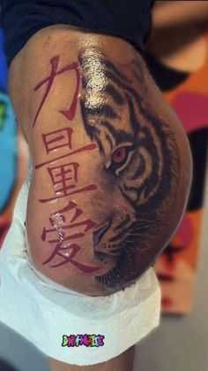 a man with a tiger tattoo on his stomach and the word tigers written in chinese