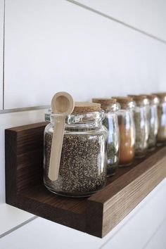 jars and spoons are lined up on a shelf