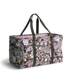 a large floral print bag with brown handles and pink linings on the bottom side