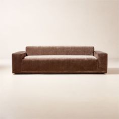 a brown couch sitting on top of a white floor