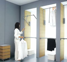 a woman standing in front of three closets with clothes hanging on the rail and two open doors