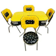 a yellow table and chairs with black dots on the top, set against a white background