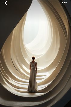 a woman is standing in front of a large white wall with curved shapes on it