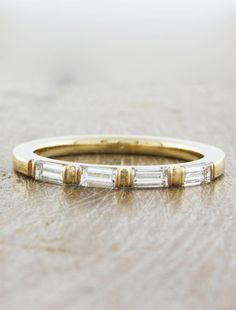 a gold and white diamond ring on a table with wood grained surface in the background