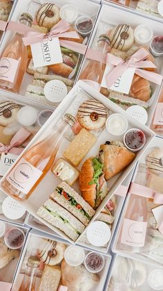 several plastic containers filled with different types of sandwiches and pastries on top of each other