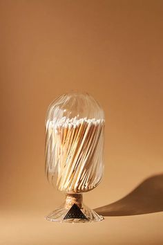 a glass vase filled with matches on top of a table