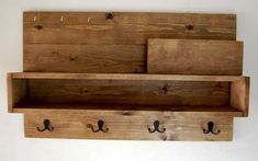 three wooden shelfs with hooks on them