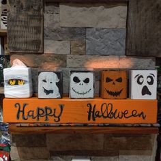 halloween decorations are on display in front of a fireplace with the words happy halloween painted on them