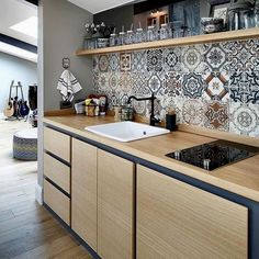 a kitchen with wooden cabinets and tile backsplashes on the wall above the sink