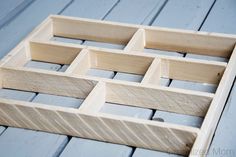 a close up of a wooden box on a table with blue wood planks and white paint