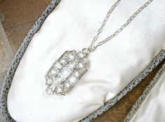 "Offering a stunning vintage Art Deco/Edwardian style pave crystal rhinestone pendant necklace. The geometric open work ornate silver rhodium plated pendant features square and baguette cut as well as round cut brilliantly clear sparkly pave set crystal rhinestones. I love the 1920s design of this one. I've hung the gorgeous pendant from the perfect dainty platinum toned SO Art Deco chain that fastens with a ring clasp. I've added an extra ring to the chain for versatility in length worn. It can Art Deco Diamond White Necklace For Wedding, Diamond White Art Deco Necklace For Wedding, Victorian Wedding Necklaces With Diamond Accents, Heirloom Silver Necklaces With Diamond Accents, Vintage White Necklace With Diamond Accents, Art Deco Filigree Necklaces For Wedding, Vintage Diamond White Necklace For Wedding, Art Deco Crystal Jewelry For Vintage Events, Art Deco Crystal Jewelry For Vintage