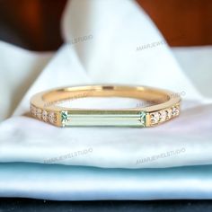 a close up of a gold ring on a white cloth with a napkin in the background