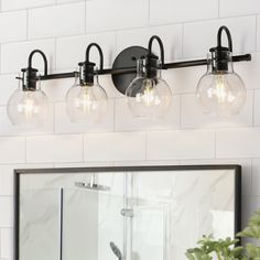 three light fixtures are mounted on the wall above a mirror