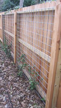 the fence is made of wood and has wire around it, along with leaves on the ground