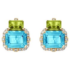 Introducing the captivating 2 Stone Peridot and Blue Topaz Emerald Cut Earrings with Diamonds in 18K Yellow Gold, a remarkable creation from the exquisite 'Gossip' Collection. Crafted with meticulous attention to detail, these earrings embody elegance and sophistication, making them a perfect accessory for any glamorous affair. Encircling the mesmerizing Blue Topaz stone is a halo of dazzling diamonds. Carefully selected for their exceptional quality and brilliant sparkle. Set in 18K yellow gold, the warm and lustrous metal enhances the rich colors of the gemstones, creating a harmonious union of elegance and beauty. The design of these earrings is both timeless and contemporary. The emerald-cut gemstones exude a classic charm, while the arrangement of the stones in a two-stone setting add Emerald Cut Earrings, Diamonds Earrings, Cut Earrings, Blue Topaz Stone, Stone Settings, Modern Jewelry, Emerald Cut, Jewelry Earrings Studs, Blue Topaz