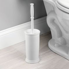 a white toilet sitting next to a white bath tub with a toothbrush in it