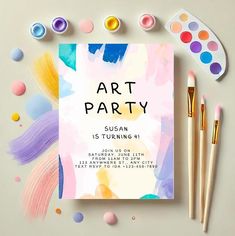 an art party flyer with paint and brushes on the table next to it, along with other items