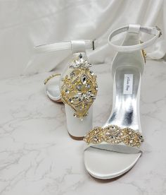 Amazing pair of satin shoes with a choice of gold accent sparkling crystals on the front or on the front and back. Sparkle coming and going! These statement wedding shoes have a heel height of approximately 3 1/8th inches. Very elegant shoes for your special day. The listing picture shoes the shoes in the ivory satin with the design on the front and the back. Another listing picture shows the design just on the front so you can decide which works best for you. Gold Open Toe Wedding Shoes With Rhinestones, Champagne Ankle Strap Wedding Shoes With Rhinestones, Luxury Gold Heels For Wedding, Gold Heels With Rhinestones For Wedding, Gold Rhinestone Heels For Wedding, Luxury Gold Wedding Heels, Gold Rhinestone Wedding Heels, White Embellished Heels For Wedding Reception, Gold Ankle Strap Wedding Shoes With Rhinestones