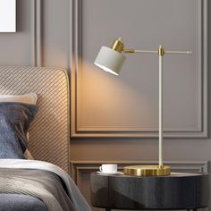 a bed with a lamp on top of it next to a night stand and side table