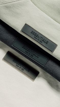 two tags are attached to the back of a white jacket with black details on it