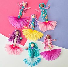 paper dolls are arranged in different colors on a pink, blue and purple background with text overlay