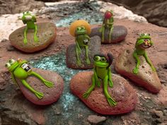 the frog figurines are sitting on some rocks