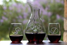 three wine glasses and a decanter on a table