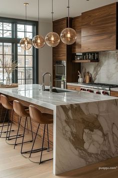 a kitchen with marble counter tops and bar stools next to an island in front of large windows