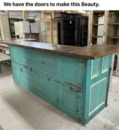 a kitchen island made out of an old door and some cupboards in the background