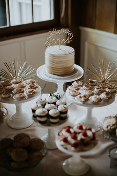 a table topped with cakes and cupcakes covered in frosting