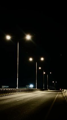 an empty street at night with lights on and no one in the dark standing there